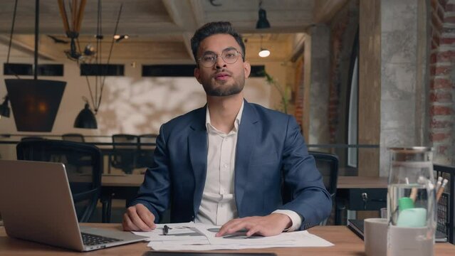 Serious Arabian Indian guy male business man employer businessman working laptop computer look camera waving finger no not never gesture forbid negative attitude stop sign reject deny refuse at office