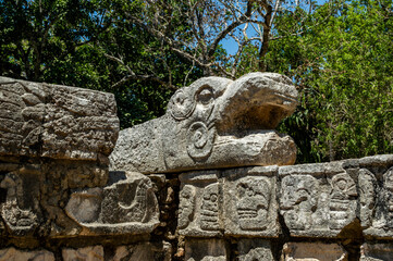snake and skulls on wall in mayan city of chichen itza, yucatan, mexico