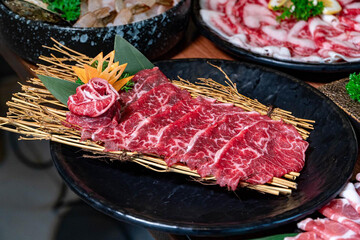 A close up detailed image of sliced Japanese wagyu beef in a ceramic plate prepared for Shabu Shab