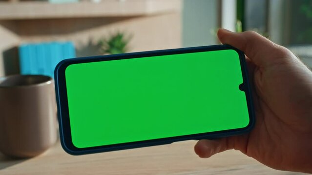 Finger tapping horizontal chroma key mobile phone at remote office close up.