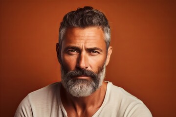 Obraz premium Handsome bearded man looking at camera. Portrait of mature man with grey beard and mustache.