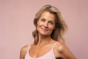 Fototapeta premium Portrait of a beautiful middle-aged woman on a pink background