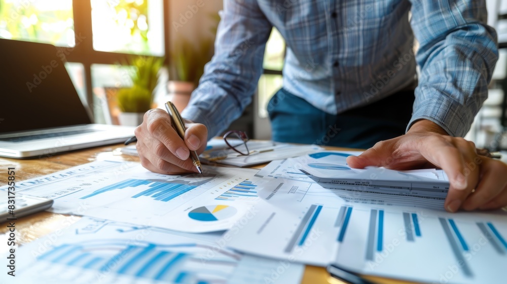Poster business professional analyzing financial documents and data in a workspace with charts and graphs. 