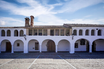 Stone arches with whitewashed walls in the main square of the Cáceres town of Garrovillas de...