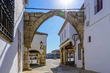 Stone arches with whitewashed walls in the main square of the Cáceres town of Garrovillas de...