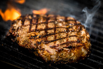 Beef steaks on the grill with flames