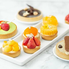 tartlets with fruits and berries in a plate on an isolated white background