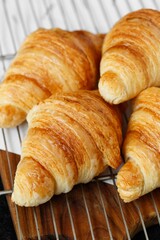 Crispy croissants baked on a wooden board, breakfast, white table, Romania