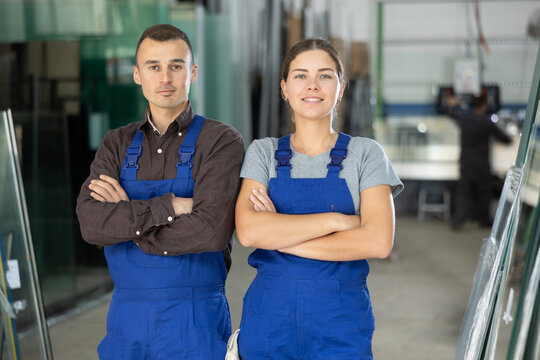 Portrait of two positive glaziers with folder of documents in a glass workshop