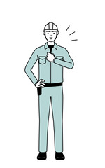 Man in helmet and workwear tapping his chest.