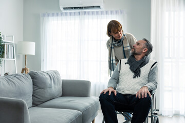 Caucasian senior wife support elderly husband sit on wheelchair at home. 