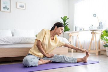 Asian young beautiful sportswoman doing yoga pilates workout at home.