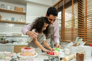 Asian attractive father making cake with daughter in kitchen at house. 