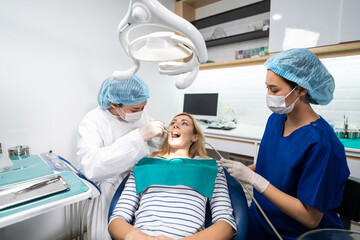 Female dentist examine tooth to Caucasian girl at dental health clinic. 