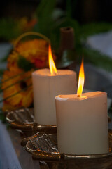 Lit candles create a cozy ambiance with a decorative flower in the background, casting a soft golden light