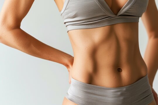 slim toned waistline and flat stomach on studio backdrop, fit female body, fitness inspiration and body positivity