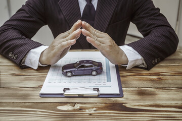 A businessman in a formal suit signs a contract, hands close up, highlighting financial terms like amortization, APR, and asset management, documents symbolizing various loan and insurance concepts.