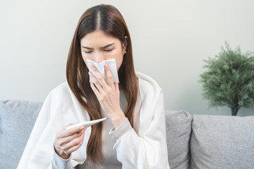 Sick, influenza asian young woman tired have a fever and sore cough hand holding thermometer for...