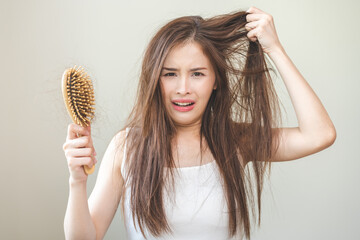 Damaged hair, amazed asian young woman, girl hand holding brush comb, hairbrush with fall hair from...