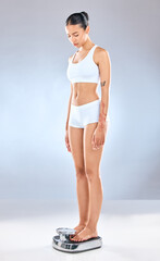 Woman, standing and scale in studio for weight loss, wellness and diet by white background....