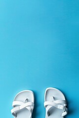 Naklejka premium Sandals isolated on baby blue background with space for text, studio lighting, minimalist photo, summer concepts