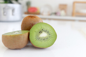 Fresh ripe whole kiwi fruit and half kiwi fruit on counter at home kitchen. Sweet and tasty fruit...