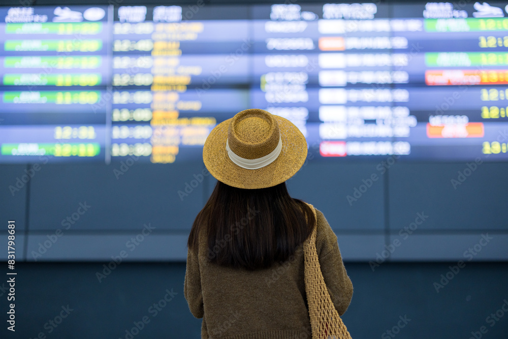 Canvas Prints Tourist woman look at the travel schedule of the flight in the airport