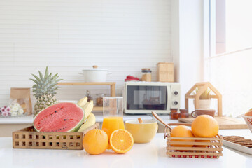 Fresh orange fruit and orange juice in jug with tropical fruit basket, watermelon, pineapple and...