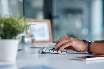 Worker, computer and hands typing at office desk for online research, copywriting and editing at...