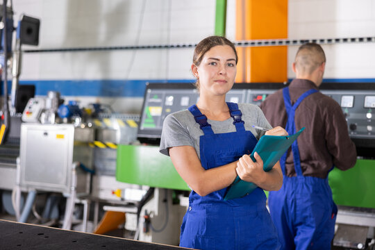 Portrait of foreman girl with folder of documents in a glass workshop