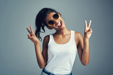 Studio, woman and funny with peace sign, confidence and trendy accessory as sunglasses. Indian...