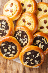 Kolache are a sweet Czech pastry made of yeast dough stuffed with homemade cottage cheese or poppy seeds closeup on the wooden table. Vertical top view from above