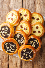 Czech and Slovak Kolach or kolace type of sweet yeast pastry filling with cottage cheese, poppy seeds closeup on the wooden table. Vertical top view from above