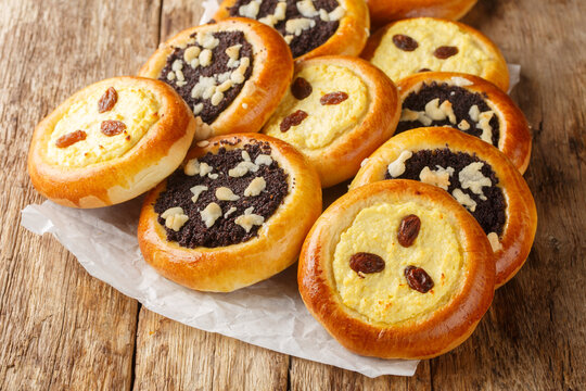 Traditional sweet yeast dough kolache kolace with delicious poppy seeds filling and streusel topping and cream cheese filling closeup on the wooden table. Horizontal