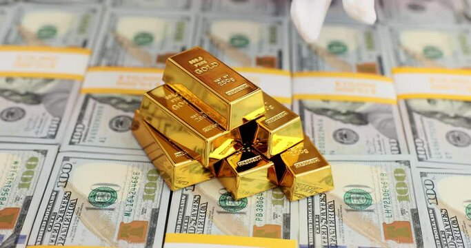 Gold bars in a stack of 100 dollar bills