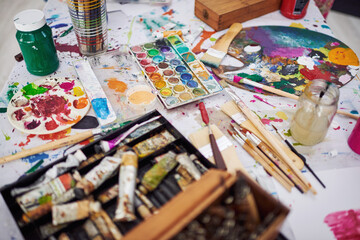 Color, art and mess with tools in studio, creative and artwork and product in apartment on floor. Equipment, texture and durability of painting brush, small business and supplies for palette and home