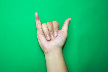 hand showing sign, sign language of alphabet of Y, on green background
