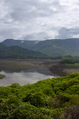 Aerial view of the Choix natural dam, with a cloudy background and green mountains