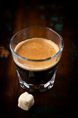 Coffee in glass cup on dark background. Close up. Copy space