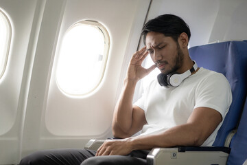 Happy young male traveler on airplane, young male passenger collecting travel concept flight travel