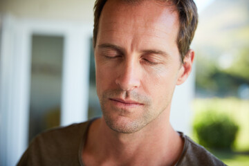 Man, serious and meditation with relax outdoor for eyes closed, mindfulness and spiritual wellness in morning. Person, calm and zen with resting in home for fresh air, peaceful and mental health