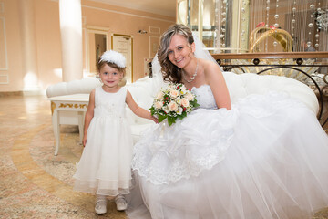 Morning of bride in white dress and elegant hairstyle. A young attractive, happy girl posing with luxurious bouquet. Happiness, purpose and dream wedding.