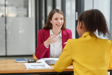 Confident African American team leader teaching employees Advice for business women Colleagues share ideas Plan work on financial projects online Discuss strategies together.