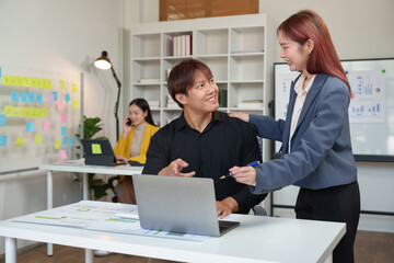 Obraz premium Young Asian businesspeople use smartphones to communicate online. Office worker making financial business call Marketing discusses customer contact work. Startup business idea.