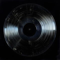 A close-up of an old, scratched vinyl record with a worn label, displayed against a dark black background