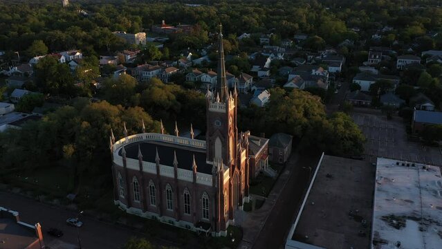 Natchez, Mississippi, USA - April 21, 2024: Sunset light shines on a historic church and landscape of downtown Natchez.
