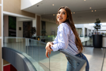 Young Woman Embraces the Dynamic Energy of Urban Living, Standing Tall Against the Backdrop of a...