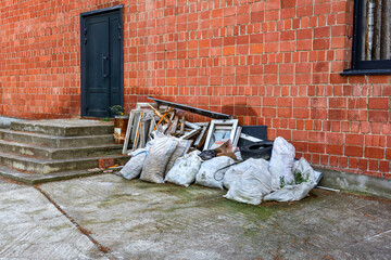 A pile of construction debris from the repair work lies next to a brick building.