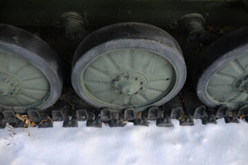 Military tank in a row. Battle tank in the snow on the roadside of highway. War in Ukraine in winter.