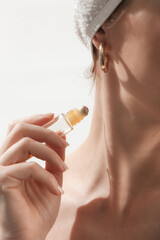 Studio shot of woman applying healing essential oil roller blend. Organic aromatherapy scent, all...